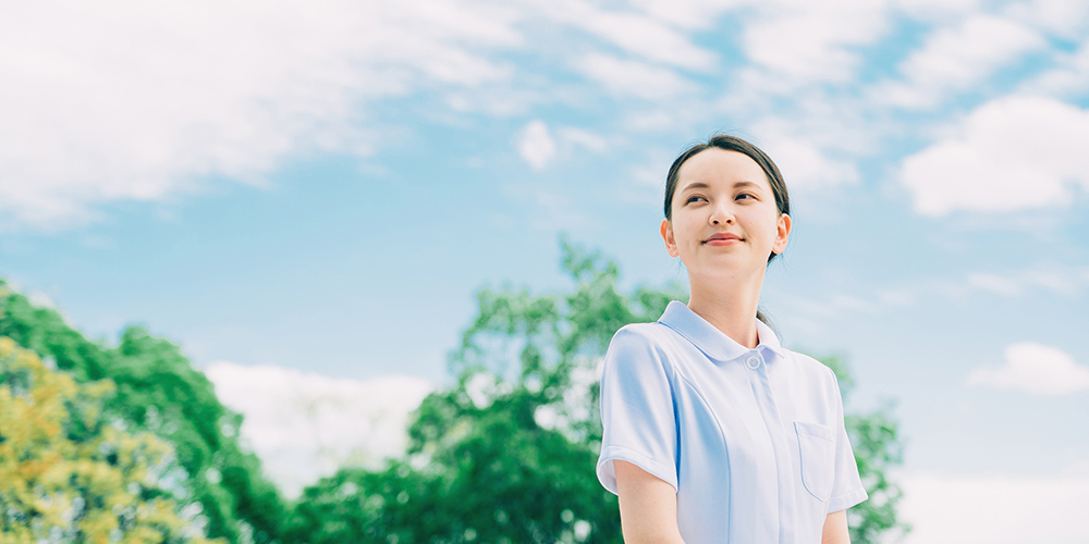 遠くの空を見つめる女性介護士