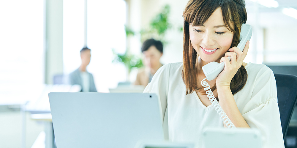 オフィスで電話応対する女性